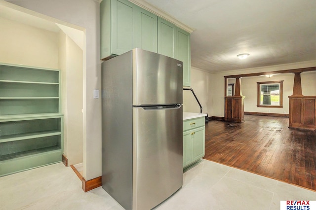 4709 Cuming St, Omaha, NE 68132 - kitchen with freestanding refrigerator, green cabinetry, light countertops, baseboards, and ornamental molding