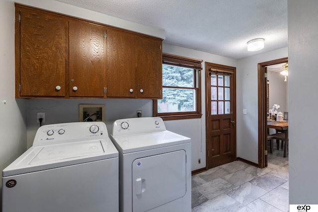 12212 Leavenworth Rd, Omaha, NE 68154 - laundry room with cabinet space, washing machine and clothes dryer, a textured ceiling, and baseboards