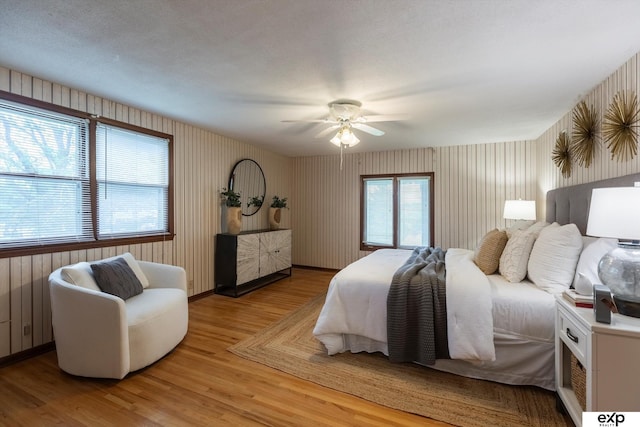 12212 Leavenworth Rd, Omaha, NE 68154 - bedroom featuring light wood-style floors, wallpapered walls, ceiling fan, and baseboards