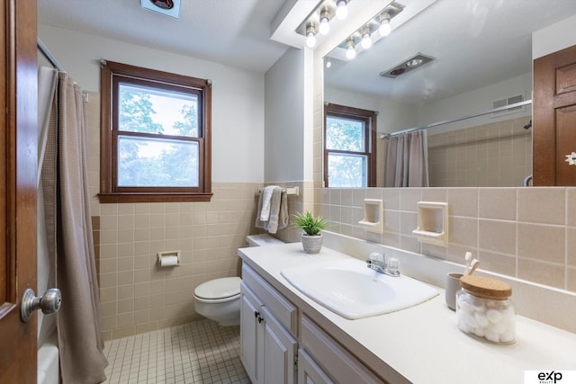 12212 Leavenworth Rd, Omaha, NE 68154 - bathroom featuring tile walls, tile patterned floors, vanity, plenty of natural light, and curtained shower
