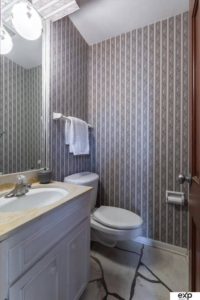 12212 Leavenworth Rd, Omaha, NE 68154 - bathroom with wallpapered walls, toilet, and vanity