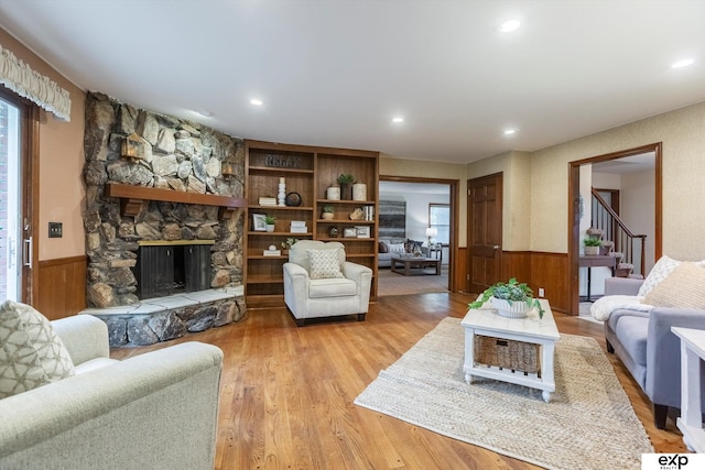 12212 Leavenworth Rd, Omaha, NE 68154 - living area with a wainscoted wall, light wood-type flooring, stairs, a stone fireplace, and recessed lighting
