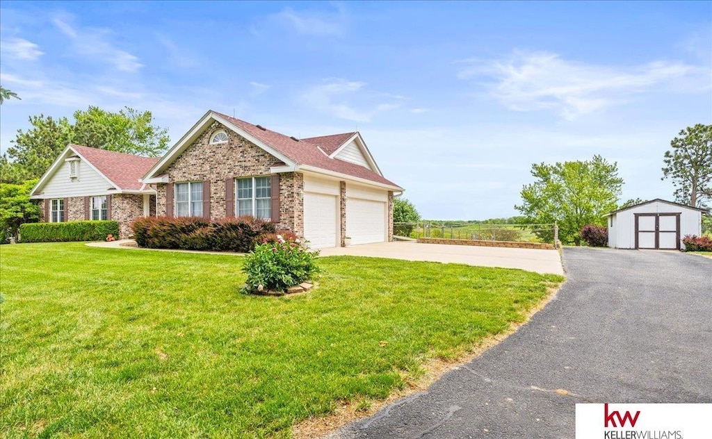 17911 Peterson Rd, Plattsmouth, NE 68048 - view of front of property featuring brick siding, a front yard, driveway, and an attached garage