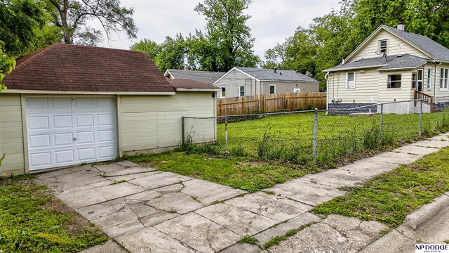 3359 N 41st St, Omaha, NE 68111 - view of yard featuring an outbuilding, concrete driveway, and a garage