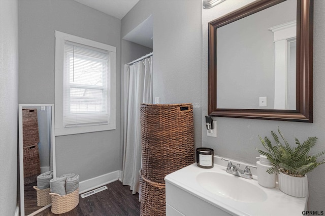 4411 Commercial Ave, Omaha, NE 68110 - bathroom featuring vanity, wood finished floors, a shower with curtain, and baseboards