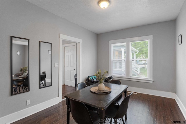 4411 Commercial Ave, Omaha, NE 68110 - dining space with dark wood-type flooring, baseboards, and a textured ceiling