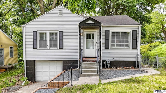 3185 Stone Ave, Omaha, NE 68111 - view of front of home with a garage, a shingled roof, and a gate