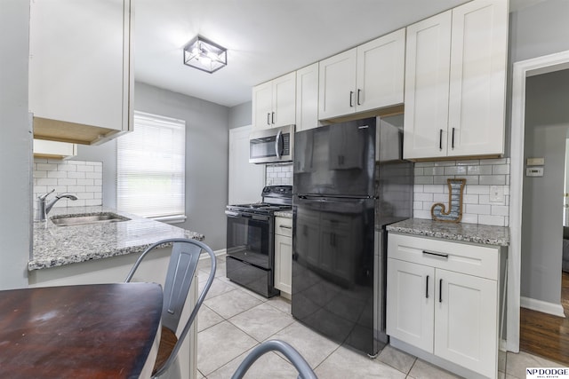 3185 Stone Ave, Omaha, NE 68111 - kitchen with black appliances, a sink, backsplash, and white cabinetry