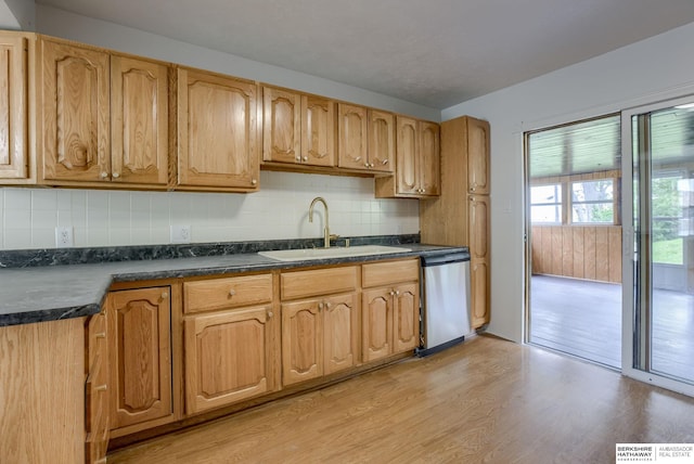 3121 State St, Omaha, NE 68112 - kitchen with stainless steel dishwasher, a sink, light wood finished floors, dark countertops, and backsplash