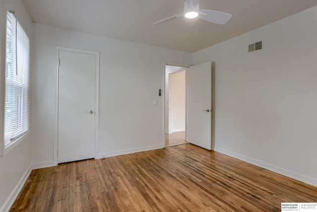 3121 State St, Omaha, NE 68112 - unfurnished bedroom with wood finished floors, multiple windows, baseboards, and ceiling fan