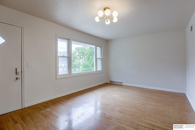 3121 State St, Omaha, NE 68112 - foyer featuring a chandelier, wood finished floors, and baseboards