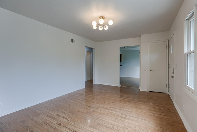 3121 State St, Omaha, NE 68112 - spare room with light wood-style floors, a chandelier, and baseboards