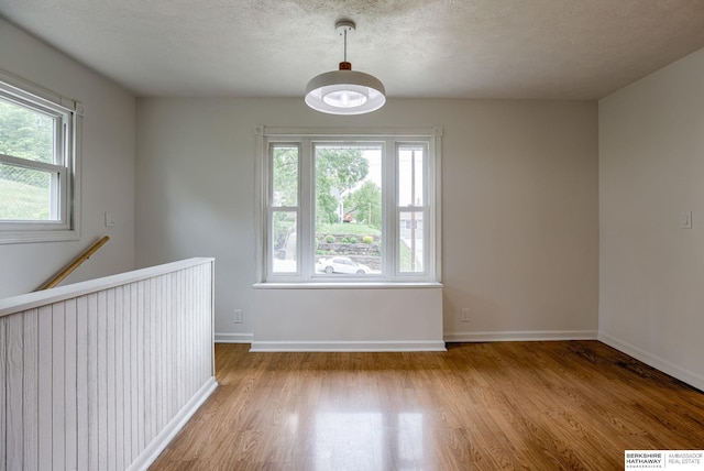 3121 State St, Omaha, NE 68112 - empty room featuring light wood-style floors, baseboards, and a textured ceiling