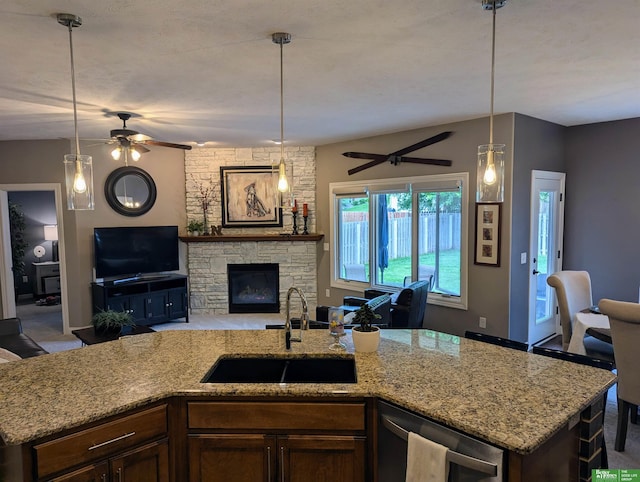 948 S 183rd St, Elkhorn, NE 68022 - kitchen featuring a sink, a ceiling fan, open floor plan, light stone counters, and a fireplace