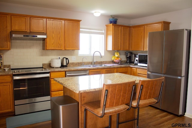 7014 N 89th St, Omaha, NE 68122 - kitchen with stainless steel appliances, under cabinet range hood, a sink, backsplash, and a kitchen island