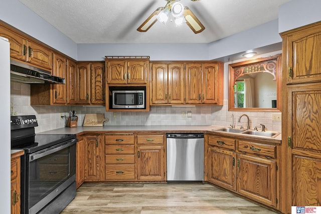 7432 Grand Oaks Dr, Lincoln, NE 68516 - kitchen featuring appliances with stainless steel finishes, under cabinet range hood, a sink, and brown cabinets