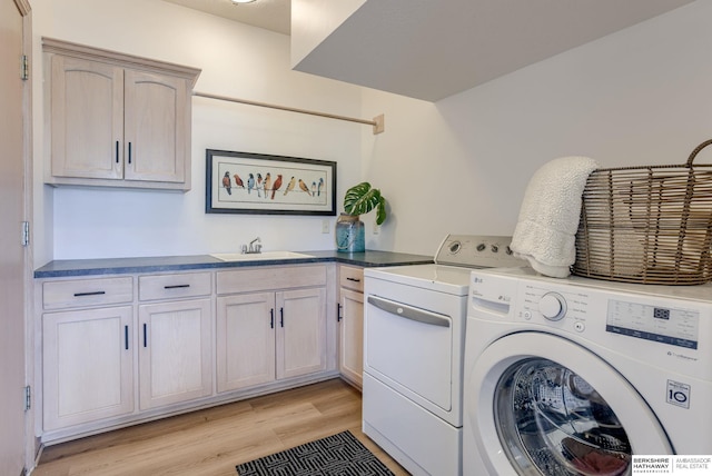 9711 S 176th St, Omaha, NE 68136 - laundry room with washer and clothes dryer, cabinet space, and light wood-type flooring