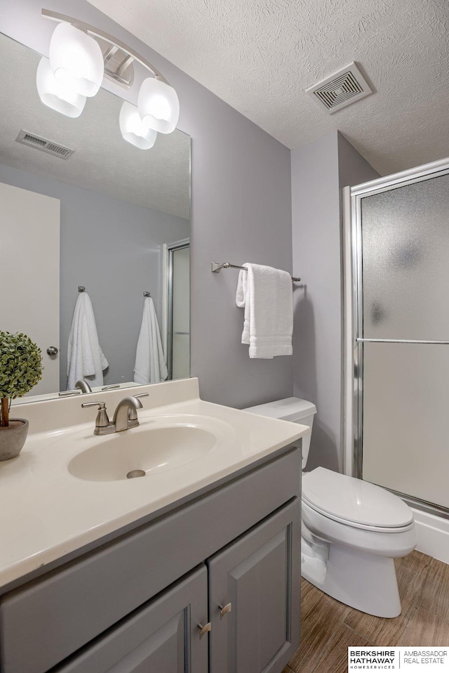 9711 S 176th St, Omaha, NE 68136 - bathroom with a stall shower, wood finished floors, vanity, and toilet