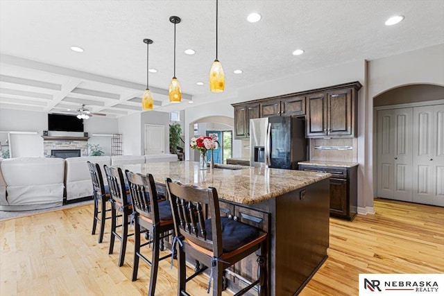 18402 Polk St, Omaha, NE 68135 - kitchen with stainless steel fridge with ice dispenser, arched walkways, coffered ceiling, recessed lighting, and dark brown cabinetry