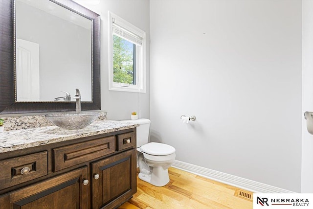 18402 Polk St, Omaha, NE 68135 - half bath featuring vanity, toilet, wood finished floors, and baseboards