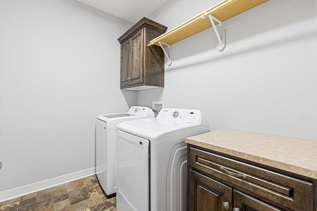 18402 Polk St, Omaha, NE 68135 - washroom featuring cabinet space, washer and clothes dryer, baseboards, and dark stone finish flooring