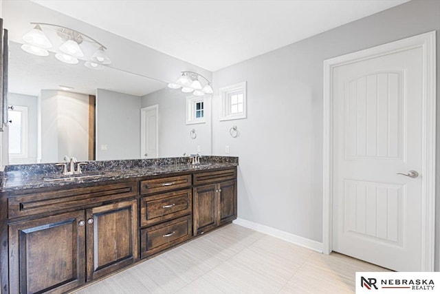 18402 Polk St, Omaha, NE 68135 - bathroom featuring double vanity, baseboards, and plenty of natural light