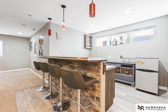 18402 Polk St, Omaha, NE 68135 - indoor wet bar featuring freestanding refrigerator, light wood-style flooring, decorative light fixtures, baseboards, and recessed lighting
