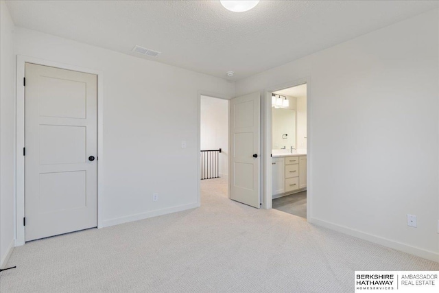 17018 Daniel St, Bennington, NE 68007 - unfurnished bedroom featuring light carpet, baseboards, ensuite bath, and a textured ceiling