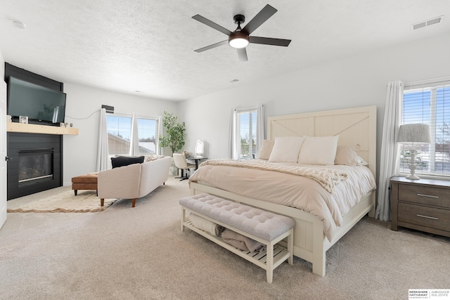 4706 S 187th Ave, Omaha, NE 68135 - carpeted bedroom with multiple windows, a fireplace, a textured ceiling, and ceiling fan