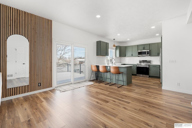 4706 S 187th Ave, Omaha, NE 68135 - kitchen with appliances with stainless steel finishes, a peninsula, green cabinets, light wood-style floors, and recessed lighting