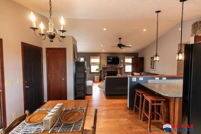29300 S Golden Pond Rd, Firth, NE 68358 - kitchen with light wood-style flooring, ceiling fan, a fireplace, hanging light fixtures, and vaulted ceiling