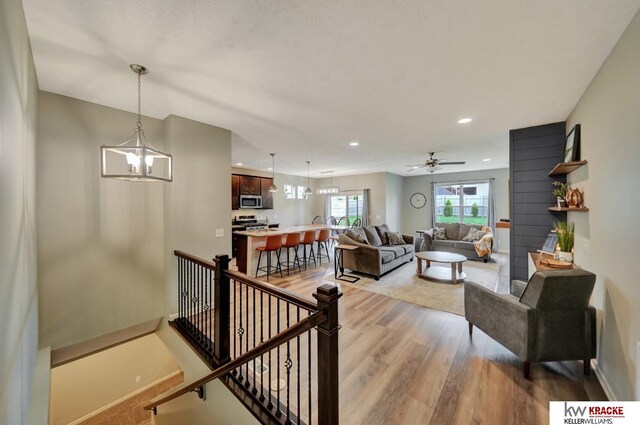 7237 Yankee Woods Dr, Lincoln, NE 68516 - living area with light wood-style flooring, recessed lighting, a ceiling fan, baseboards, and a chandelier