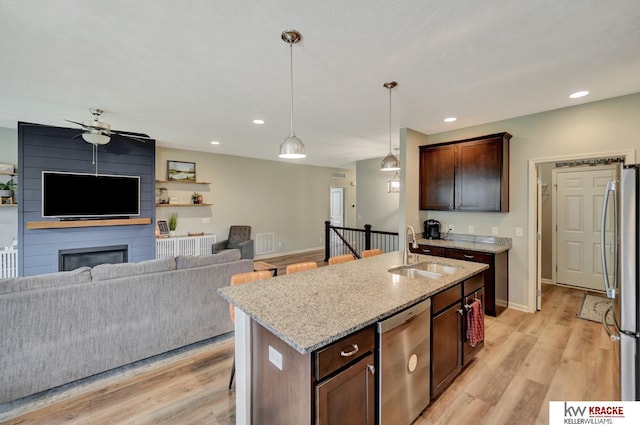 7237 Yankee Woods Dr, Lincoln, NE 68516 - kitchen with a sink, stainless steel appliances, open floor plan, light stone counters, and recessed lighting