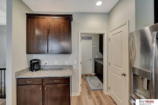 7237 Yankee Woods Dr, Lincoln, NE 68516 - kitchen with stainless steel refrigerator with ice dispenser, light wood-style floors, dark brown cabinetry, light stone counters, and recessed lighting