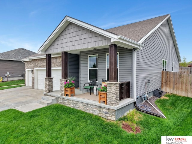 7237 Yankee Woods Dr, Lincoln, NE 68516 - rear view of property featuring a porch, an attached garage, concrete driveway, and a shingled roof