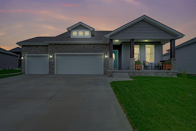 7237 Yankee Woods Dr, Lincoln, NE 68516 - view of front of house with a porch, stone siding, a lawn, driveway, and a garage