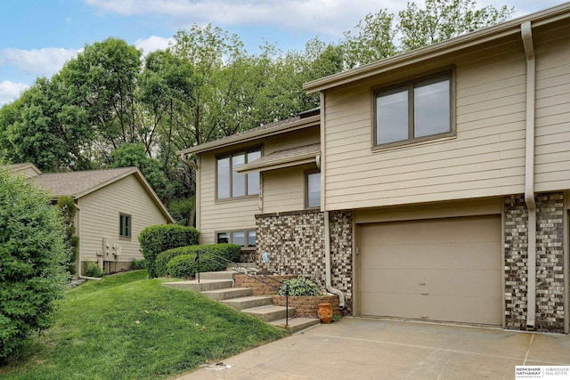 1115 Arbor Ridge Dr, Council Bluffs, IA 51503 - view of front of house featuring brick siding, a garage, concrete driveway, and a front lawn