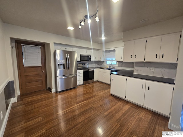 713 Janes View St, Papillion, NE 68046 - kitchen with stainless steel appliances, dark wood-style floors, dark countertops, a sink, and white cabinetry