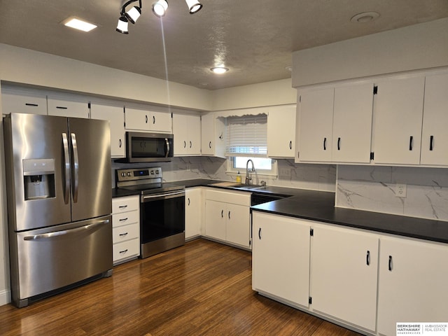 713 Janes View St, Papillion, NE 68046 - kitchen with stainless steel appliances, dark countertops, a sink, dark wood finished floors, and white cabinets