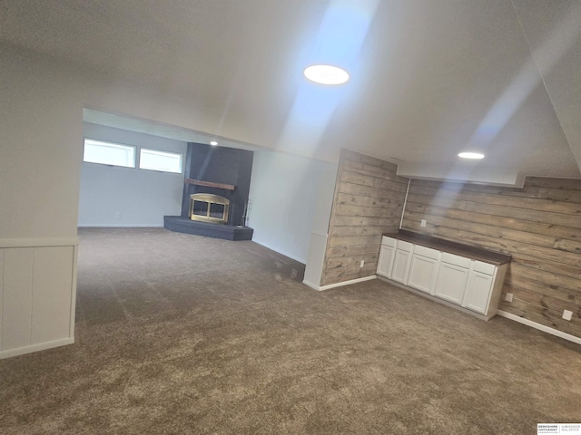 713 Janes View St, Papillion, NE 68046 - unfurnished living room with dark carpet, a large fireplace, wooden walls, and baseboards