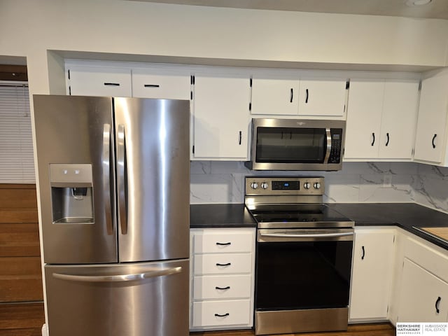 713 Janes View St, Papillion, NE 68046 - kitchen with appliances with stainless steel finishes, dark countertops, white cabinetry, and backsplash