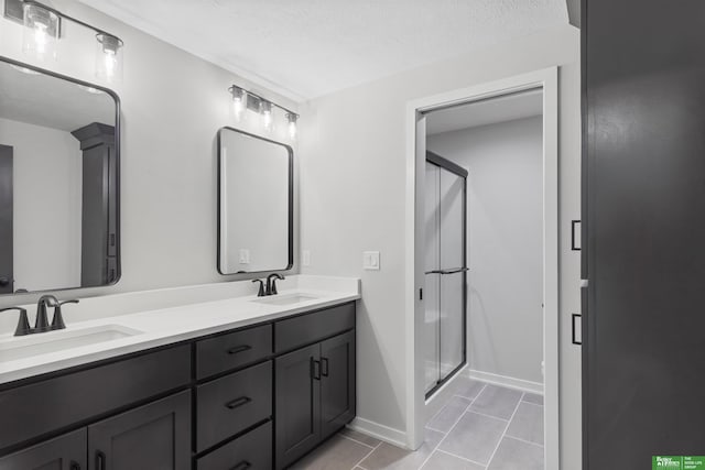 5408 N 196th Ave, Elkhorn, NE 68022 - bathroom featuring double vanity, a stall shower, baseboards, tile patterned floors, and a textured ceiling