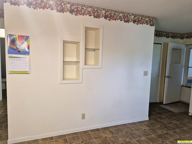 64070 67th Hwy, Peru, NE 68421 - empty room featuring built in features, baseboards, and a textured ceiling
