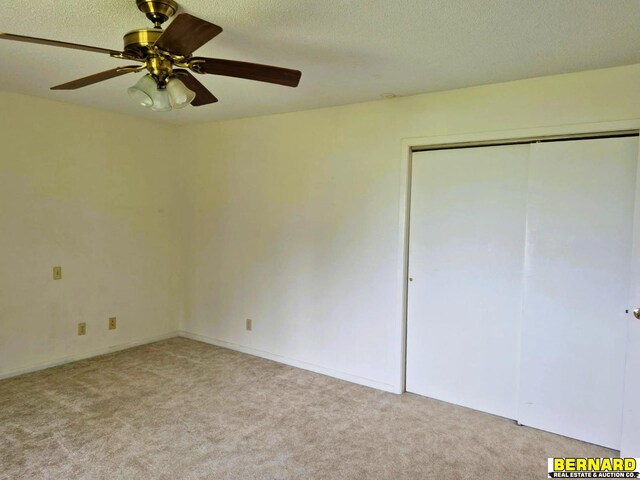 64070 67th Hwy, Peru, NE 68421 - unfurnished bedroom with carpet, a closet, a ceiling fan, and a textured ceiling