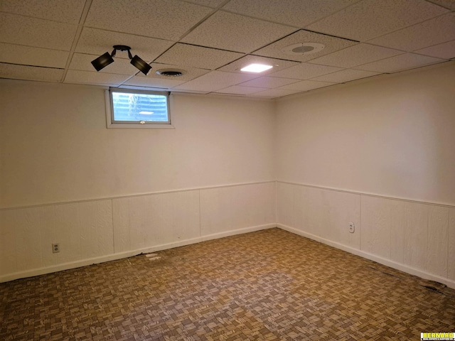 64070 67th Hwy, Peru, NE 68421 - basement featuring a drop ceiling, a wainscoted wall, and baseboards