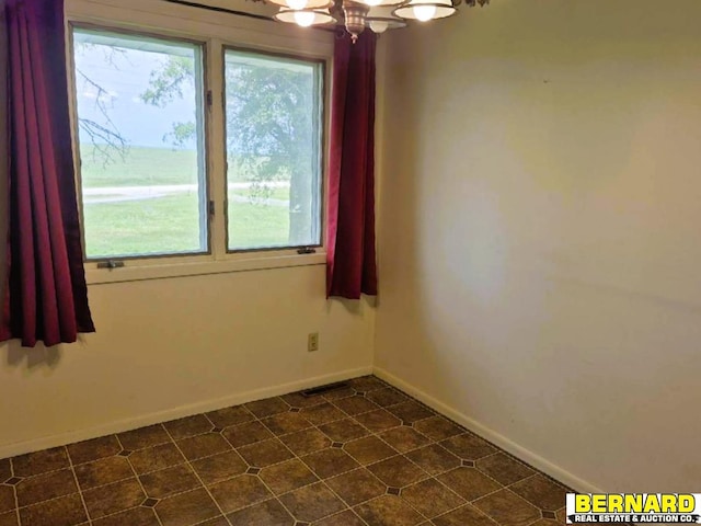 64070 67th Hwy, Peru, NE 68421 - spare room featuring baseboards, a chandelier, and dark floors