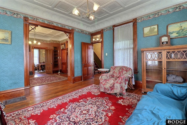 450 W 6th St, Fremont, NE 68025 - sitting room featuring hardwood / wood-style flooring, a chandelier, stairs, ornamental molding, and wallpapered walls