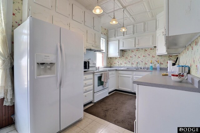 450 W 6th St, Fremont, NE 68025 - kitchen featuring white appliances, wallpapered walls, a sink, white cabinets, and pendant lighting