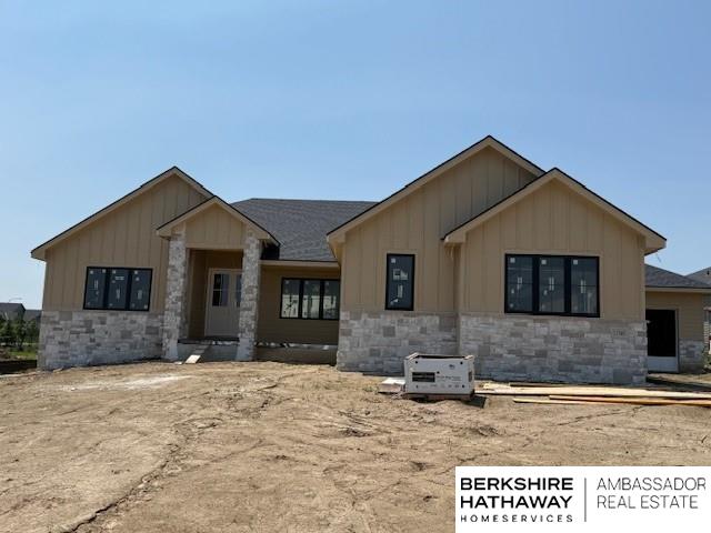 11560 S 123rd Ave, Papillion, NE 68046 - view of front of house with board and batten siding, stone siding, and roof with shingles