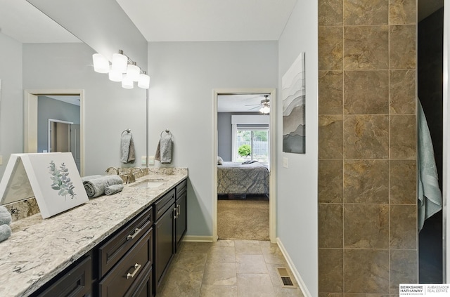 504 S 198th St, Elkhorn, NE 68022 - bathroom featuring connected bathroom, vanity, baseboards, stone finish flooring, and tiled shower